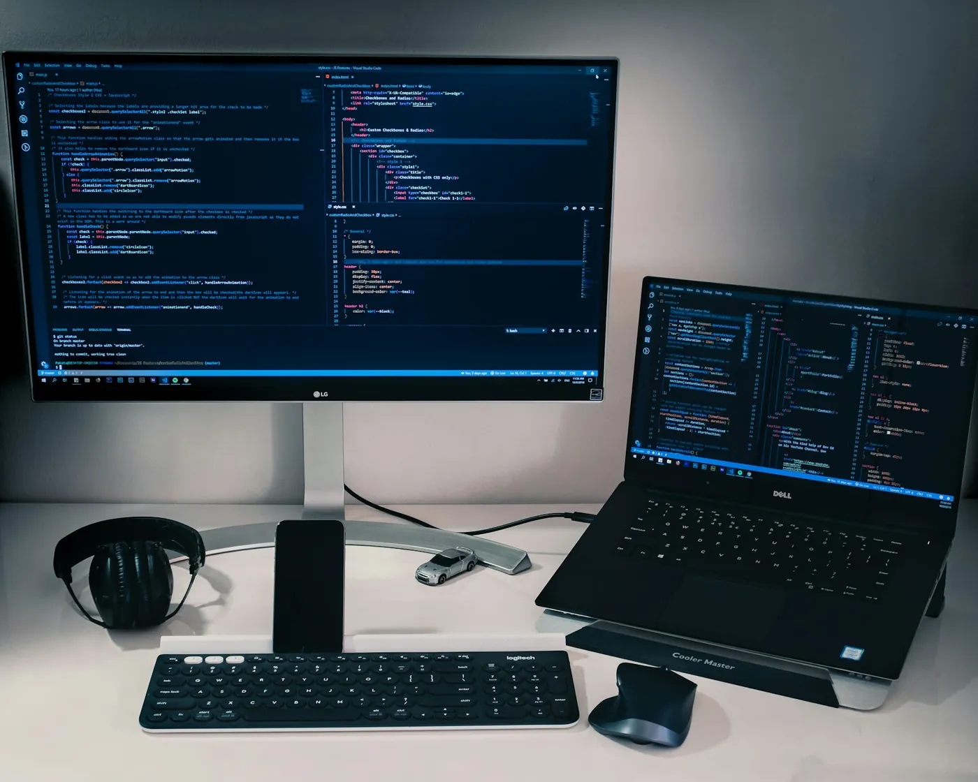 A laptop beside a monitor, keyboard and mouse on a desk