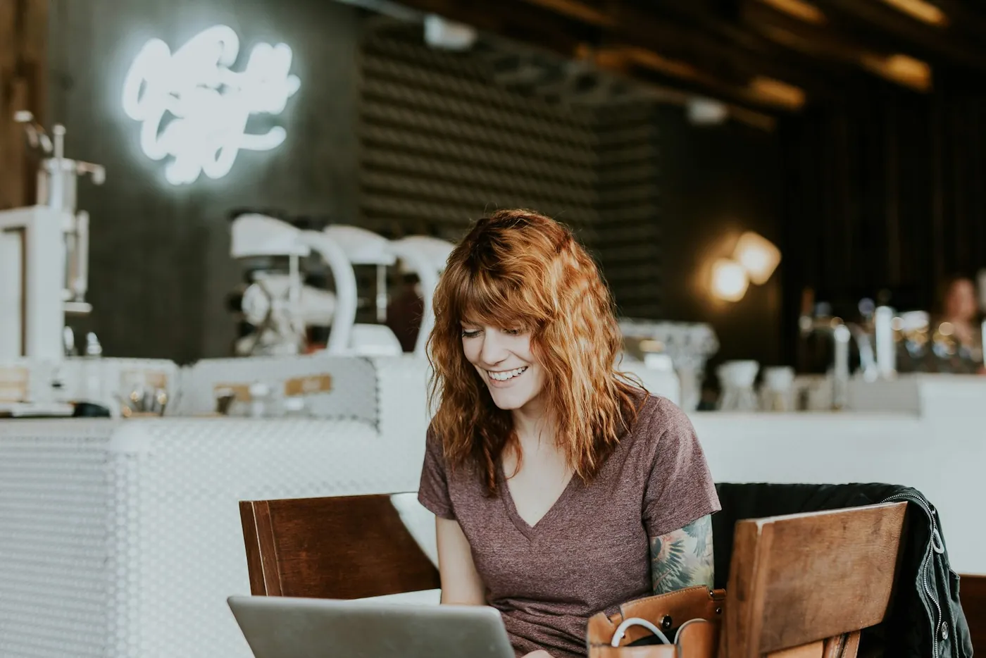 A woman working at a laptop in a wooden chair