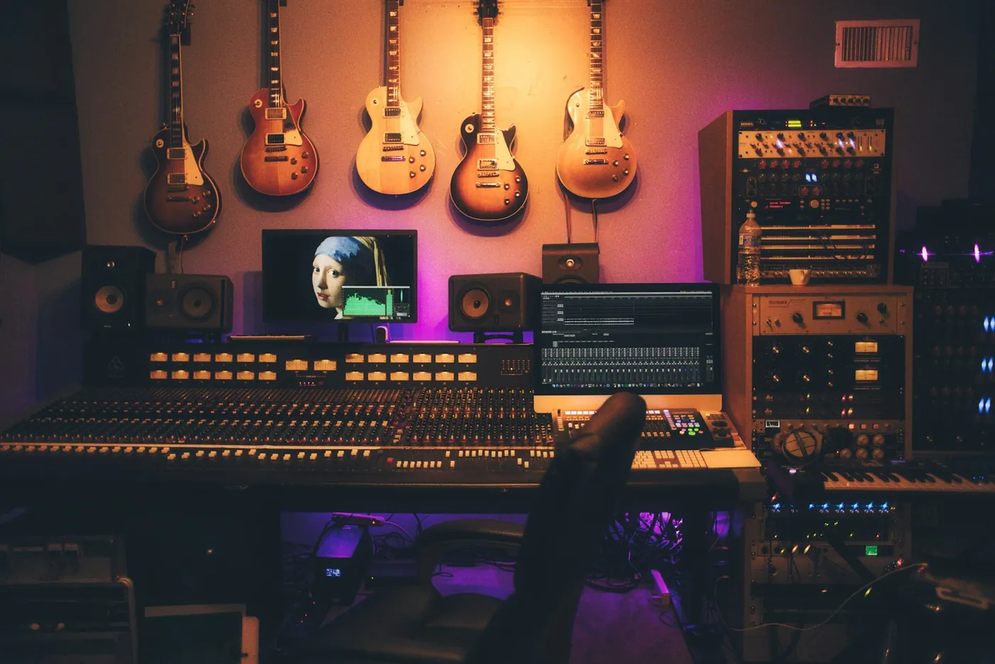 A recording studio with guitars on the wall