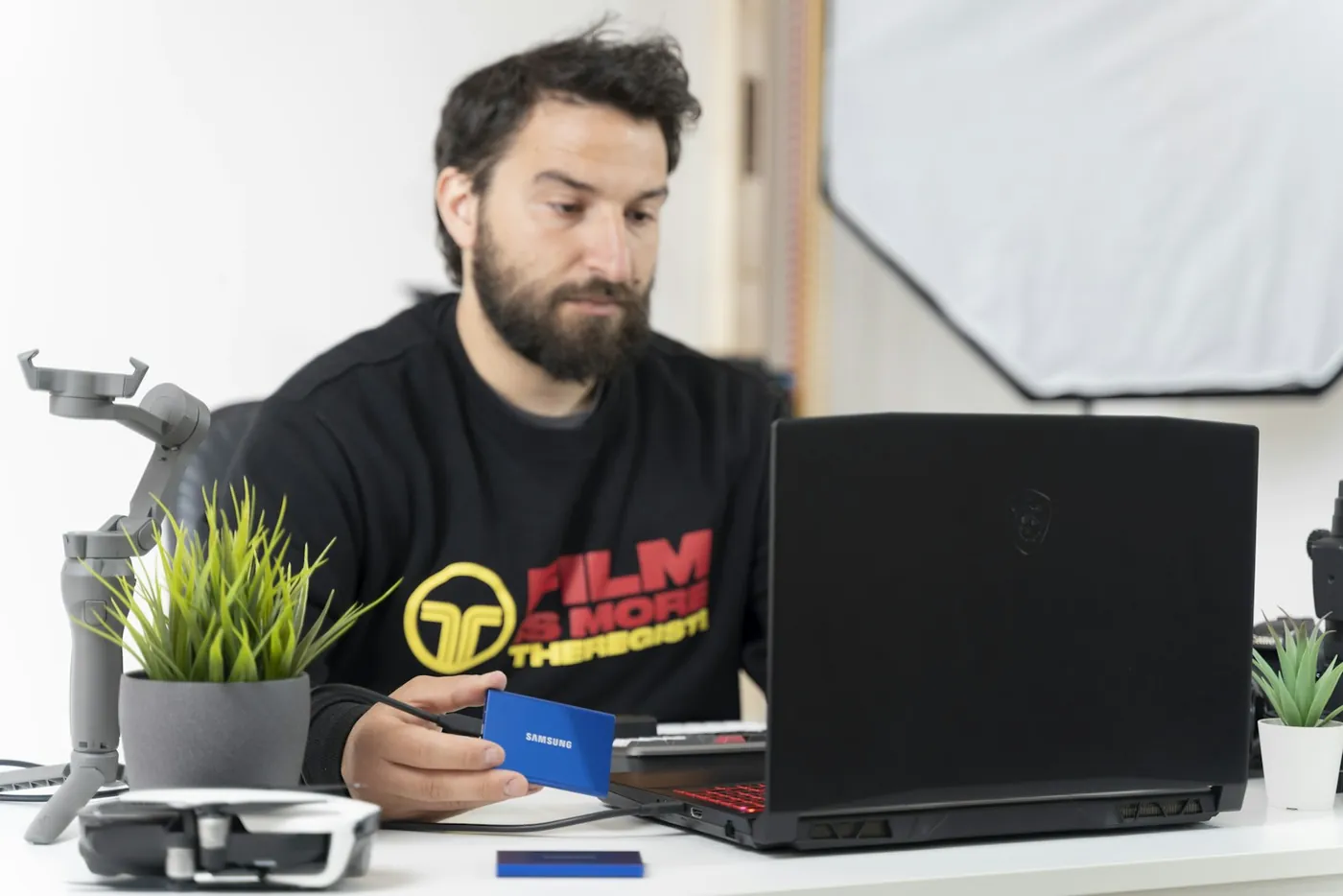 A creator working at a desk with a laptop and a microphone