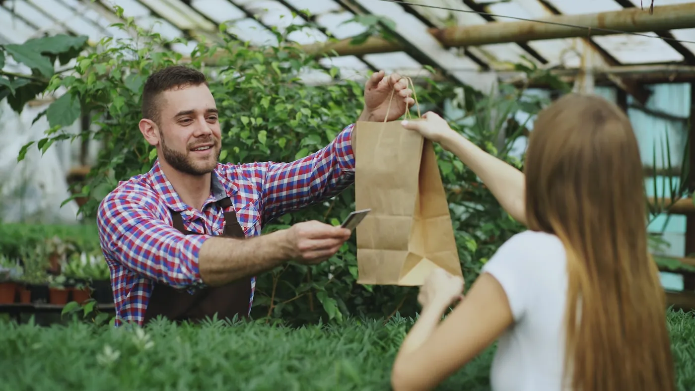 A man handing a paper bag to a customer