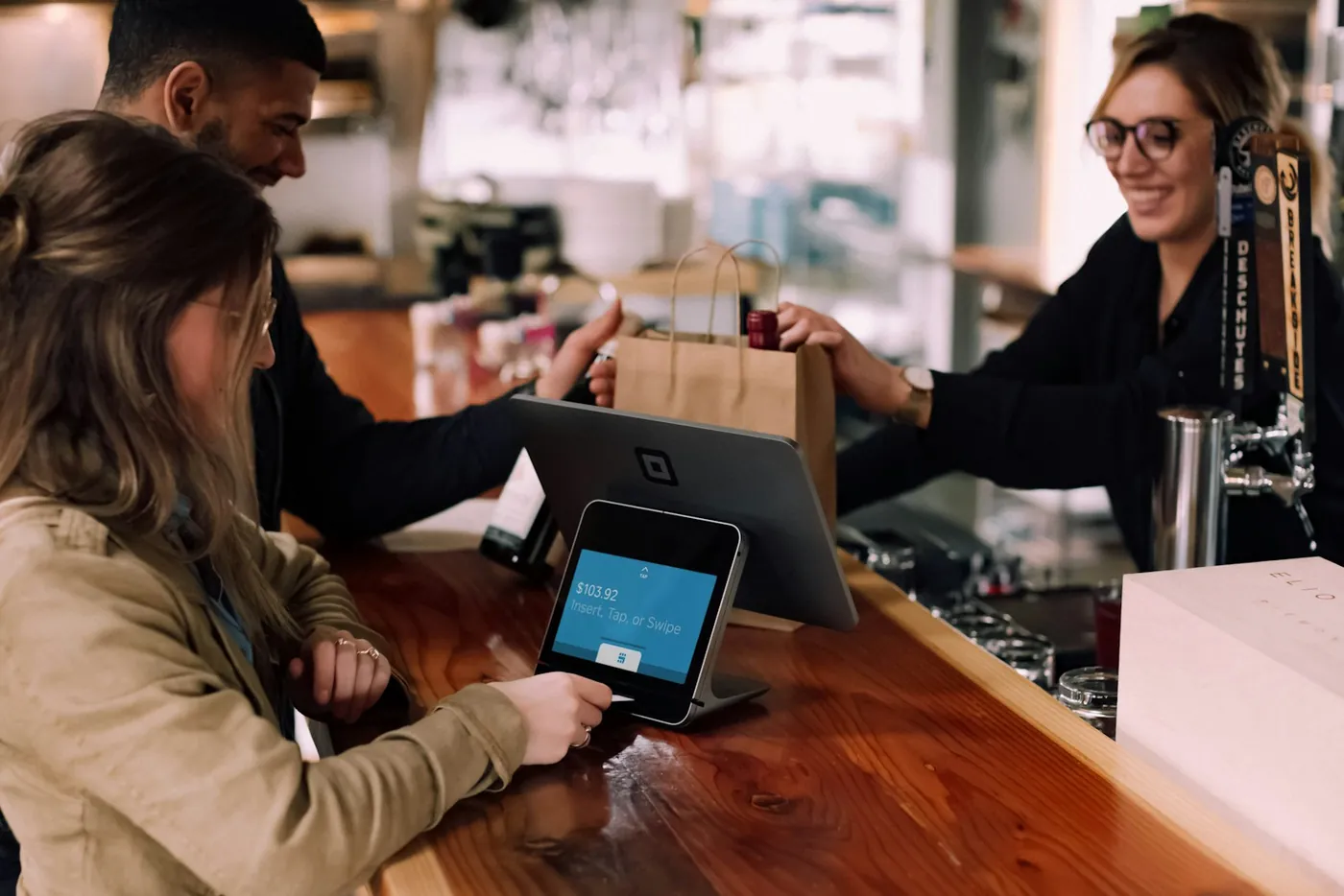 People using devices around a wooden table