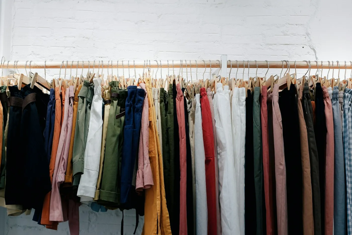 Assorted clothes hanging on a wall rack