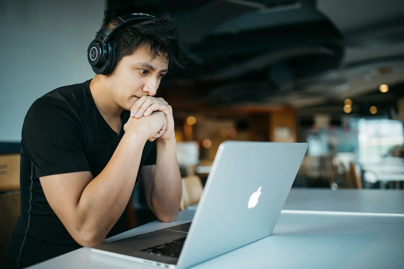 Someone working at a laptop wearing headphones