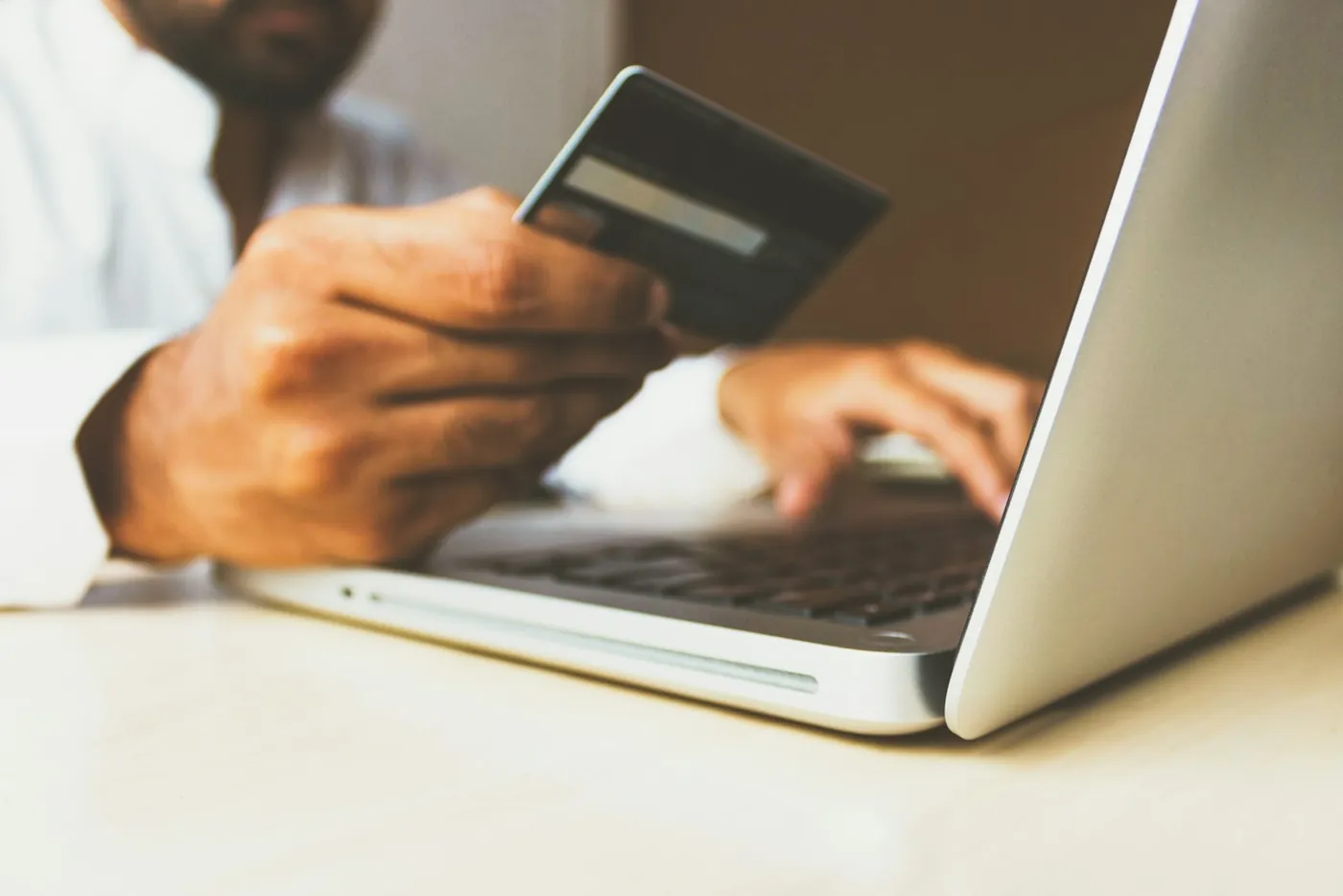 A person at a laptop holding a card