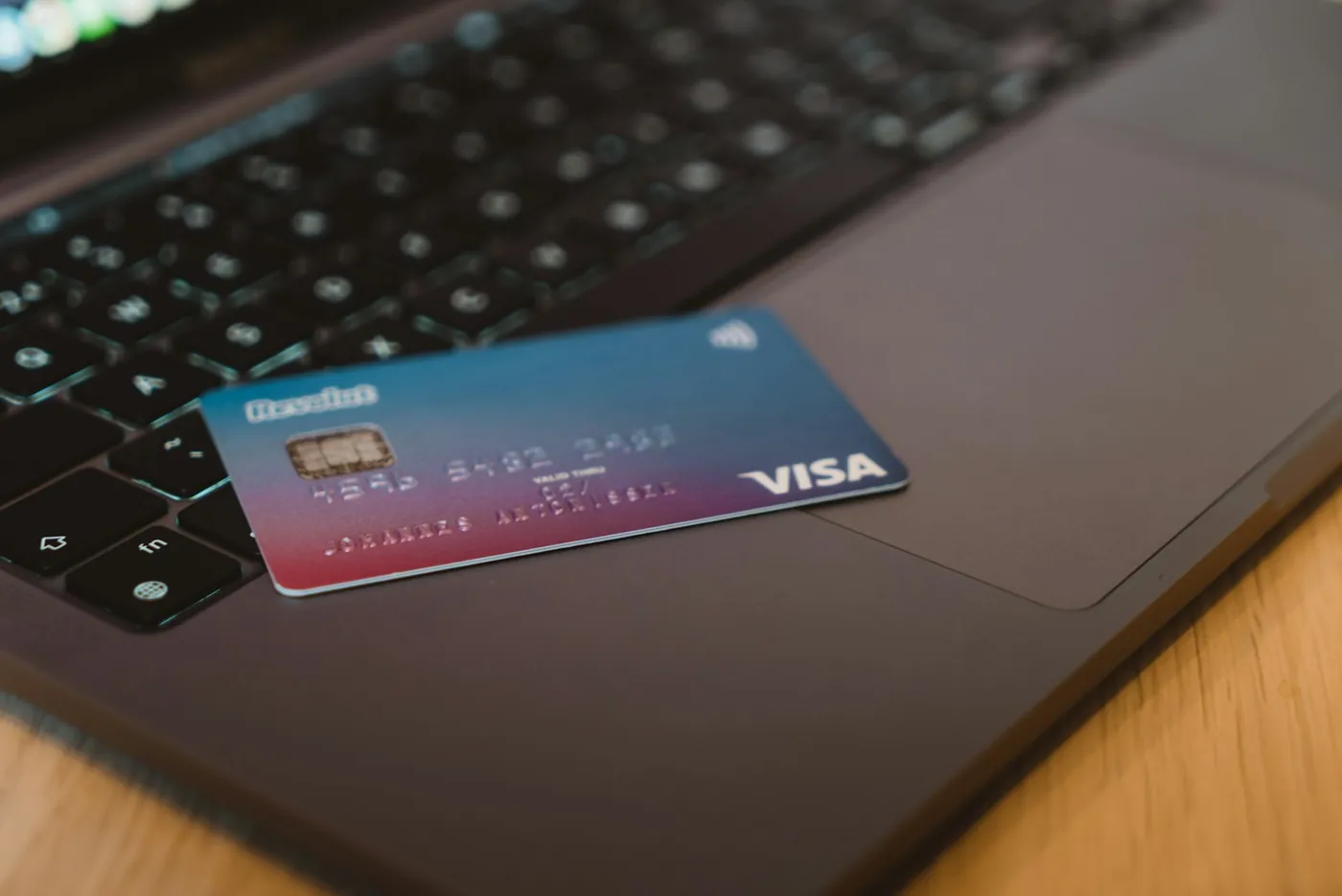 A debit card resting on a laptop